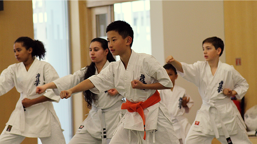 les enfants font des mouvements d'arts martiaux de karaté de base, posent  des combats et
