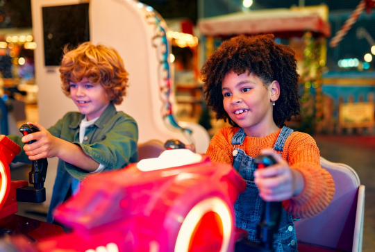 Jeux vidéo : Deux jeunes s'amusent sur un simulateur de courses en moto