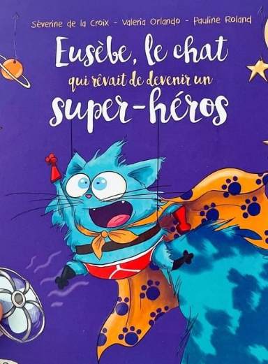 Une main montre le livre "Eusèbe, le chat qui rêvait de devenir un super-héros"