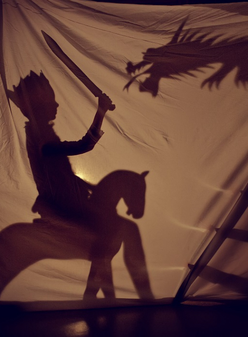 Nuits de la lecture : Un petit garçon déguisé en chevalier en ombre derrière une toile tendue