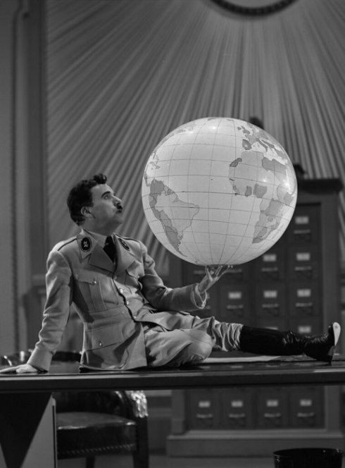 Ciné-concert Le Dictateur : Chaplin sur un bureau avec un globe terrestre dans la main
