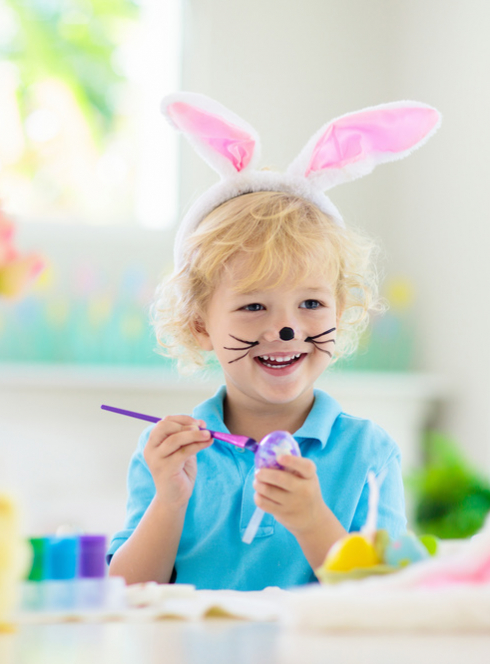 Enfant qui peint un oeuf de Pâques