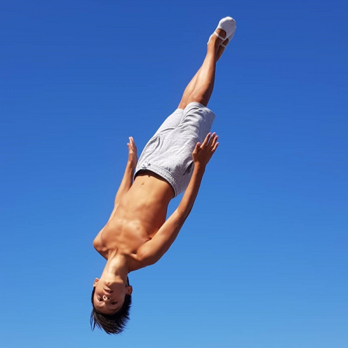 Kelotrampo : Un jeune garçon saute en l'air, figure acrobatique sur trampoline