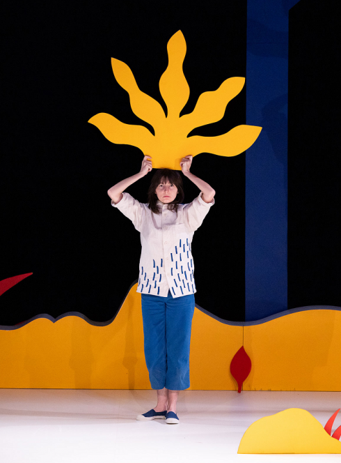 Marcher dans le vent, une petite fille porte au dessus de sa tête un arbre en papier