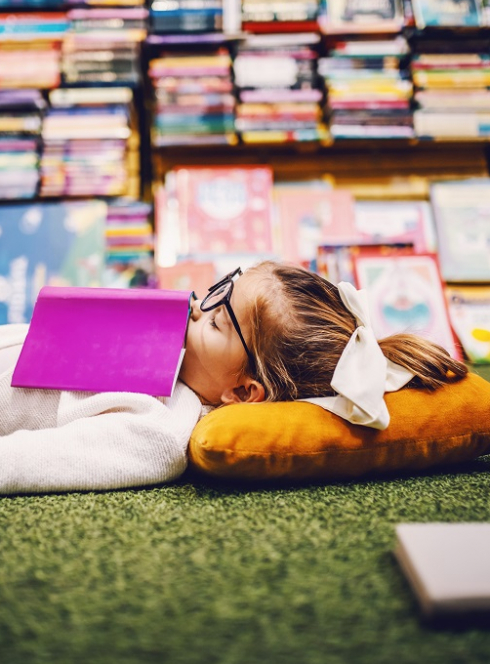 Festival du Livre de Nice 2024 : Petite fille allongée au milieu de livres