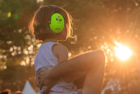 Festival Rio Loco : Une petite fille sur les épaules de son papa profite d'un concert en toute sécurité au coucher du soleil
