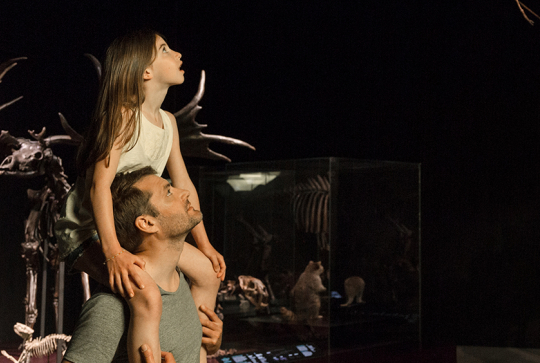 Musée des confluences Lyon 2024 : une petite fille sur les épaules de son père devant un squelette de dinosaure