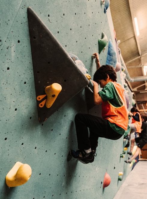 Arkose Lille : Un petit garçon grimpe sur un mur d'escalade