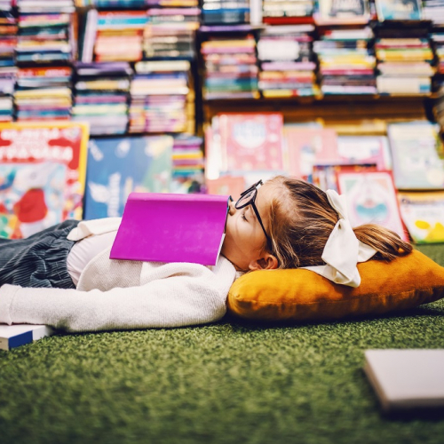 Festival du Livre de Nice 2024 : Petite fille allongée au milieu de livres