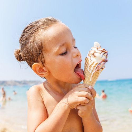 Top glaciers : Un petit garçon sur la plage déguste une glace