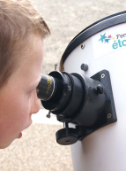 Festival d'Astronomie : Un petit garçon observe le ciel grâce à un instrument optique