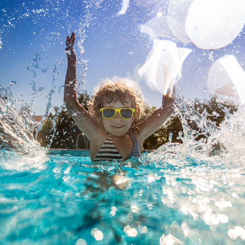 Enfant sautant dans une piscine en été