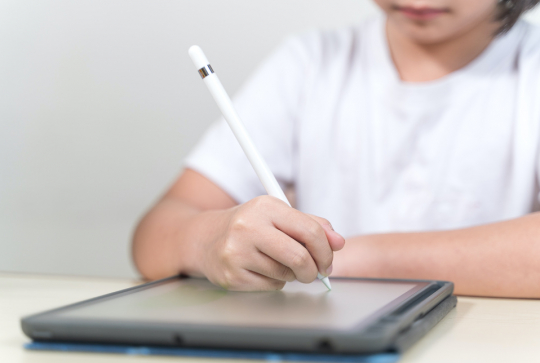Un enfant en apprentissage d'anglais sur une tablette