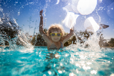 Enfant sautant dans une piscine en été