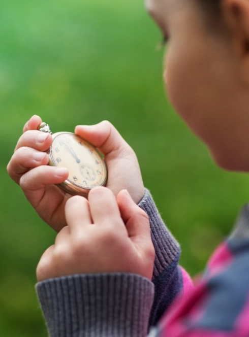 Fille qui regarde une montre à gousset