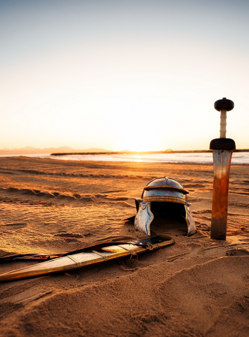 Spectacle historique Lou Misteriou : Casque et épée sur la plage au coucher de soleil