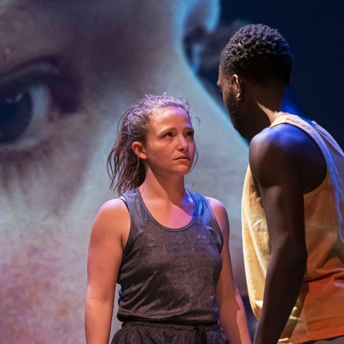 Celle qui regarde le monde : Une femme et un homme se font face sur scène