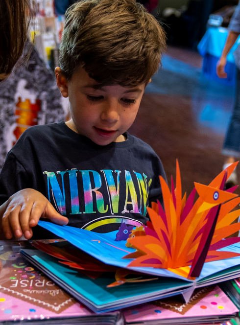Festival Livre Jeunesse : Un enfant ouvre un livre en 3D