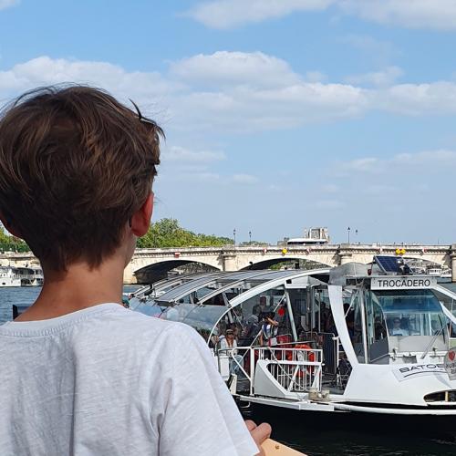 Enfant face à un Batobus sur la Seine