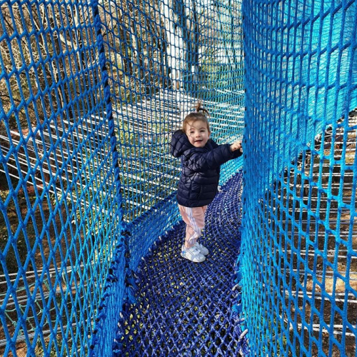 Vikings Parc : Une petite fille s'aventure dans un parcours en filets marins dans les arbres