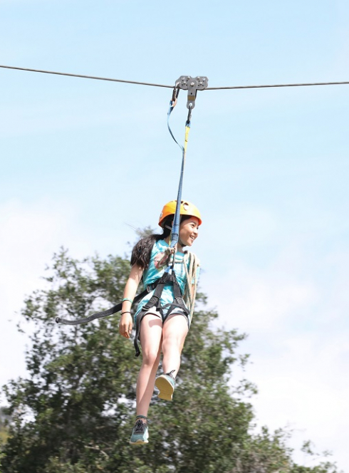 Top parcs de loisirs : une petite fille sur une tyrolienne