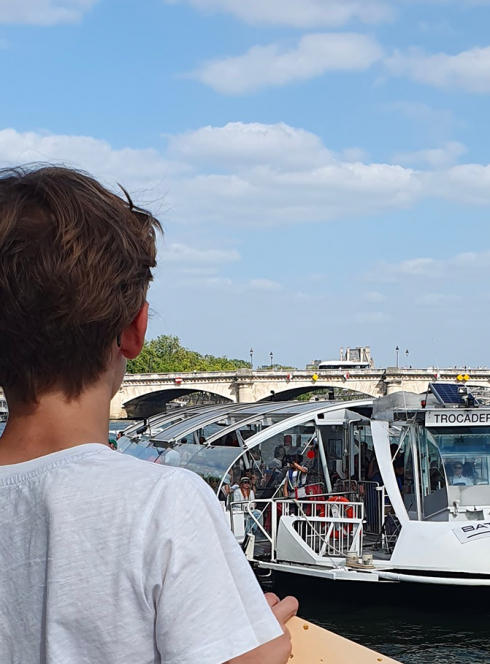 Enfant face à un Batobus sur la Seine