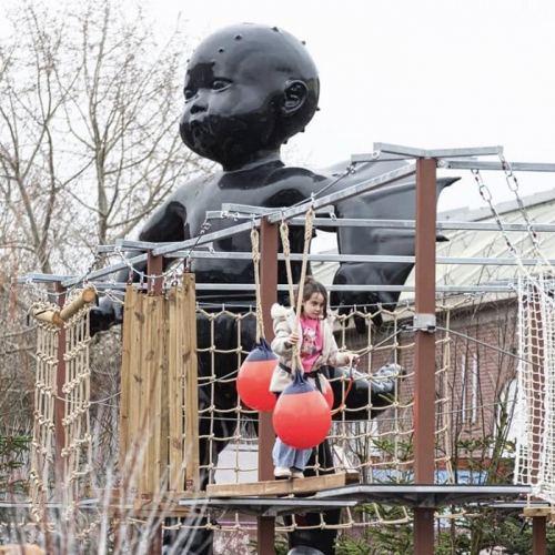 Lille Neige 2025 : Une petite fille fais de l'accrobranche devant une statue de bébé noir