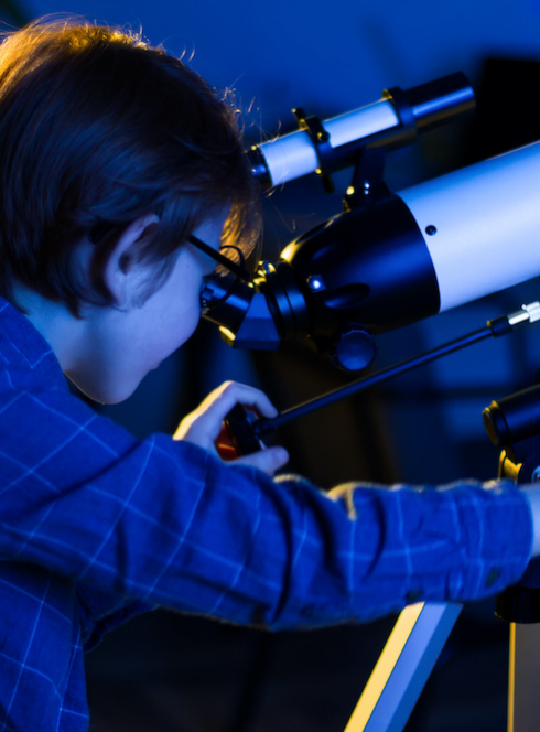 Nuit des Étoiles : Un petit garçon observe le ciel avec un instrument optique