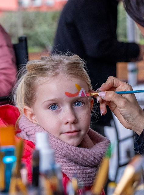 Carnaval des Kids à Villeneuve-Loubet : Une petite fille blonde aux yeux bleus entrain de se faire maquiller