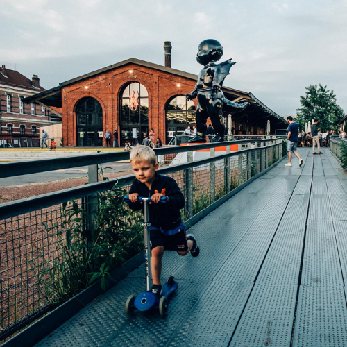 Printemps 2024 Gare Saint Sauveur : Petit garçon qui fait de la trottinette devant l'établissement