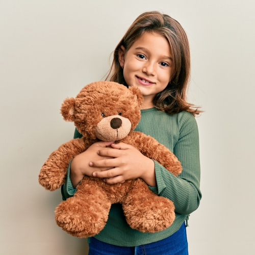 Léon l'ourson et Peter l'oiseau migrateur - Amélie Abrieu : Une petite fille tient dans se bras un ourson en peluche