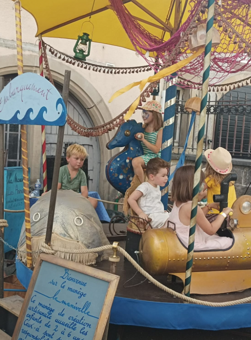 Festival des Mômes : des enfants sur un petit manège d'antan