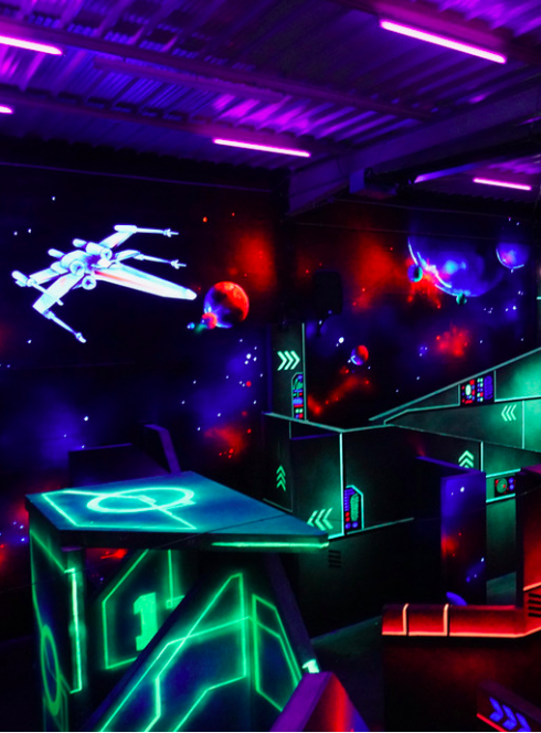 Star Laser Game - Genas : Salle Falcon 1 plongée dans la pénombre avec des néons fluorescents