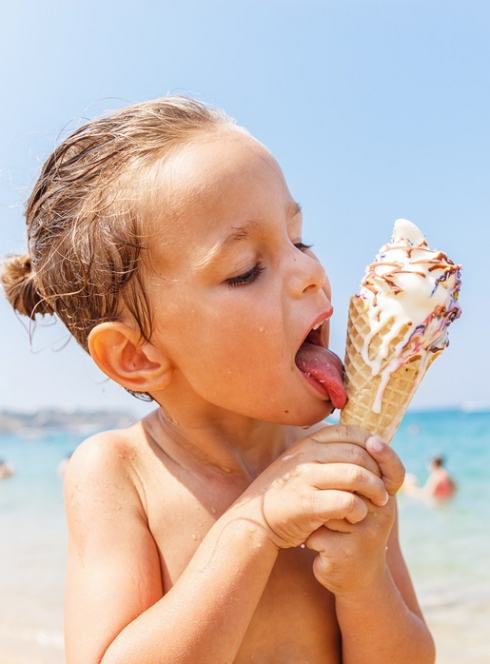 Top glaciers : Un petit garçon sur la plage déguste une glace