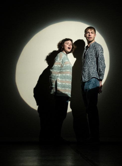 Dominique toute seule : Un couple d'artistes devant un rond de lumière