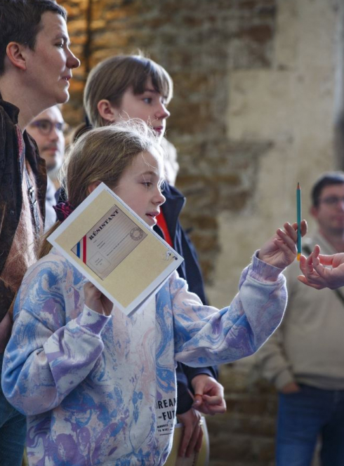 Mini-exposition CHRD Madeleine Riffaud, résitante, petite qui prend un crayon à papier lors d'une visite  guidée
