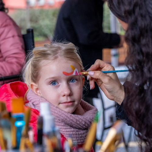 Carnaval des Kids à Villeneuve-Loubet : Une petite fille blonde aux yeux bleus entrain de se faire maquiller