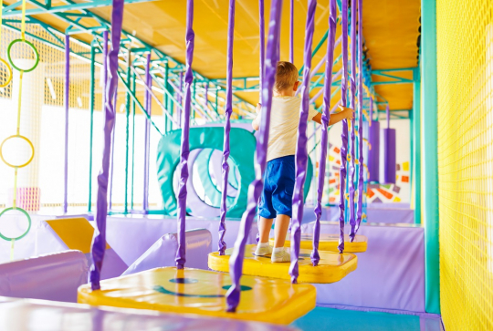 Structure de jeux indoor pour les enfants : Un peu garçons s'amuse sur une structure d'équilibre
