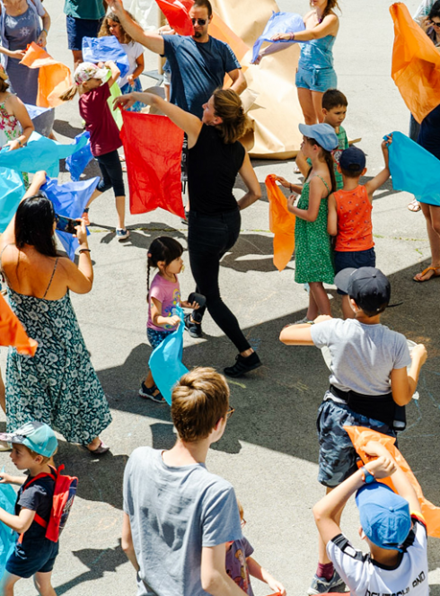 Ideklic : Des enfants et des parents agitent des foulards colorés