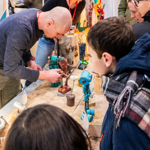 Braderie de l'art 2024 : Des enfants regardent un artiste travaillé
