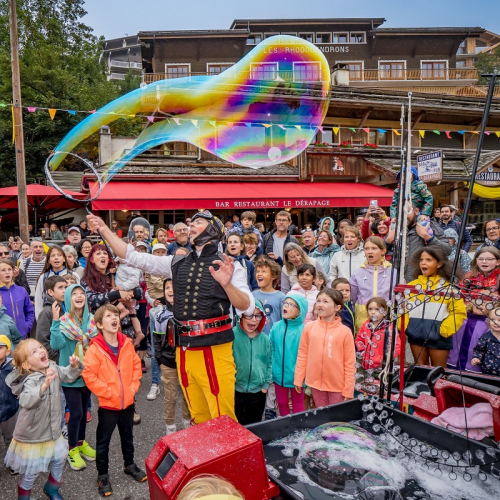 Festival Au Bonheur des Mômes : Des enfants regardent un artiste de rue faire des énormes bulles de savon