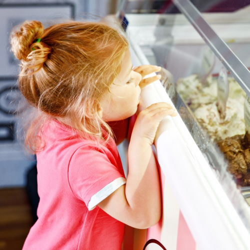 Une petite fille regarde des parfums de glace