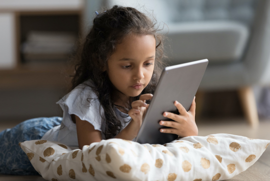 Une fillette sur une tablette pour apprendre l'anglais