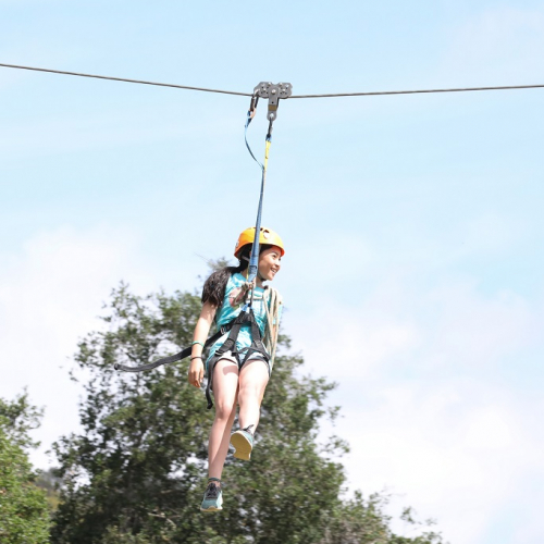 Top parcs de loisirs : une petite fille sur une tyrolienne