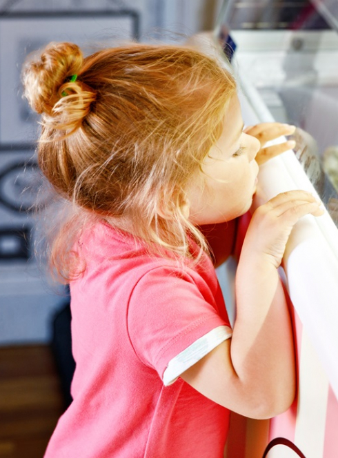 Une petite fille regarde des parfums de glace