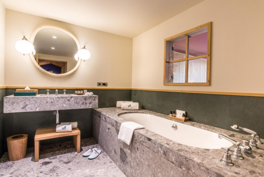 Salle de bain en marbre gris de l'hôtel Coucou Méribel