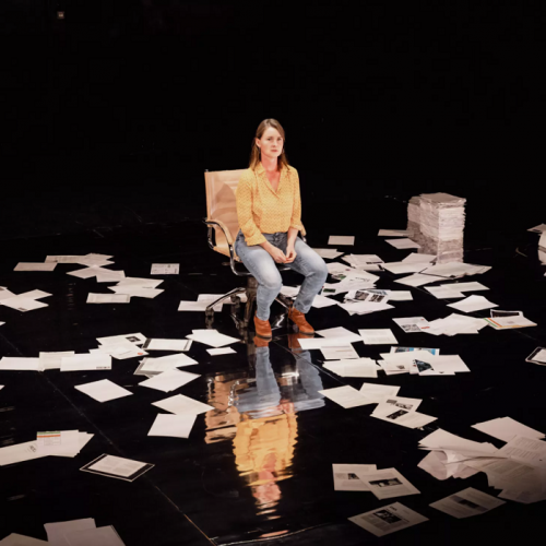 L'araignée - Cie La Chair du Monde : Une femme assise sur une chaise au milieu de feuilles par terre