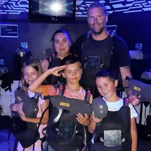 Laser Game Evolution Nice : Une famille pose après avoir fait une partie