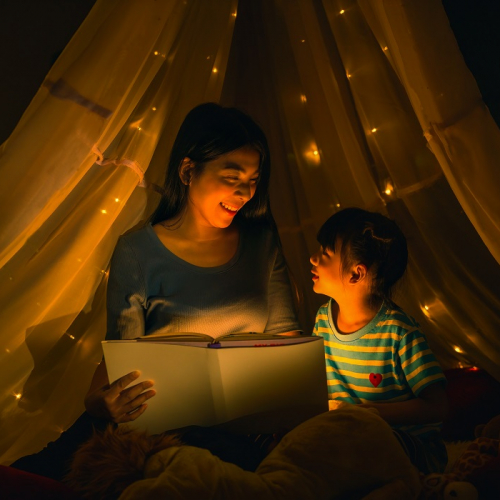 Les Nuits de la lecture : Une mère et sa fille lisent un livre sous une tente