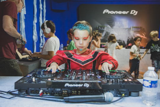 Un enfant mixe sur des platines au Mini Rock en Seine
